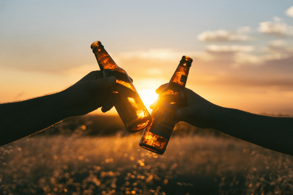 toasting of beers during a sunset
