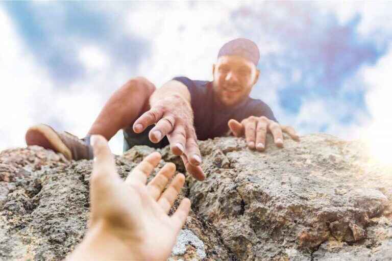 adventurers helping each other to climb