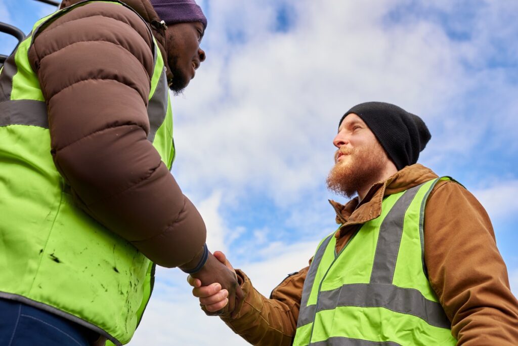 workers shaking hands outdoors